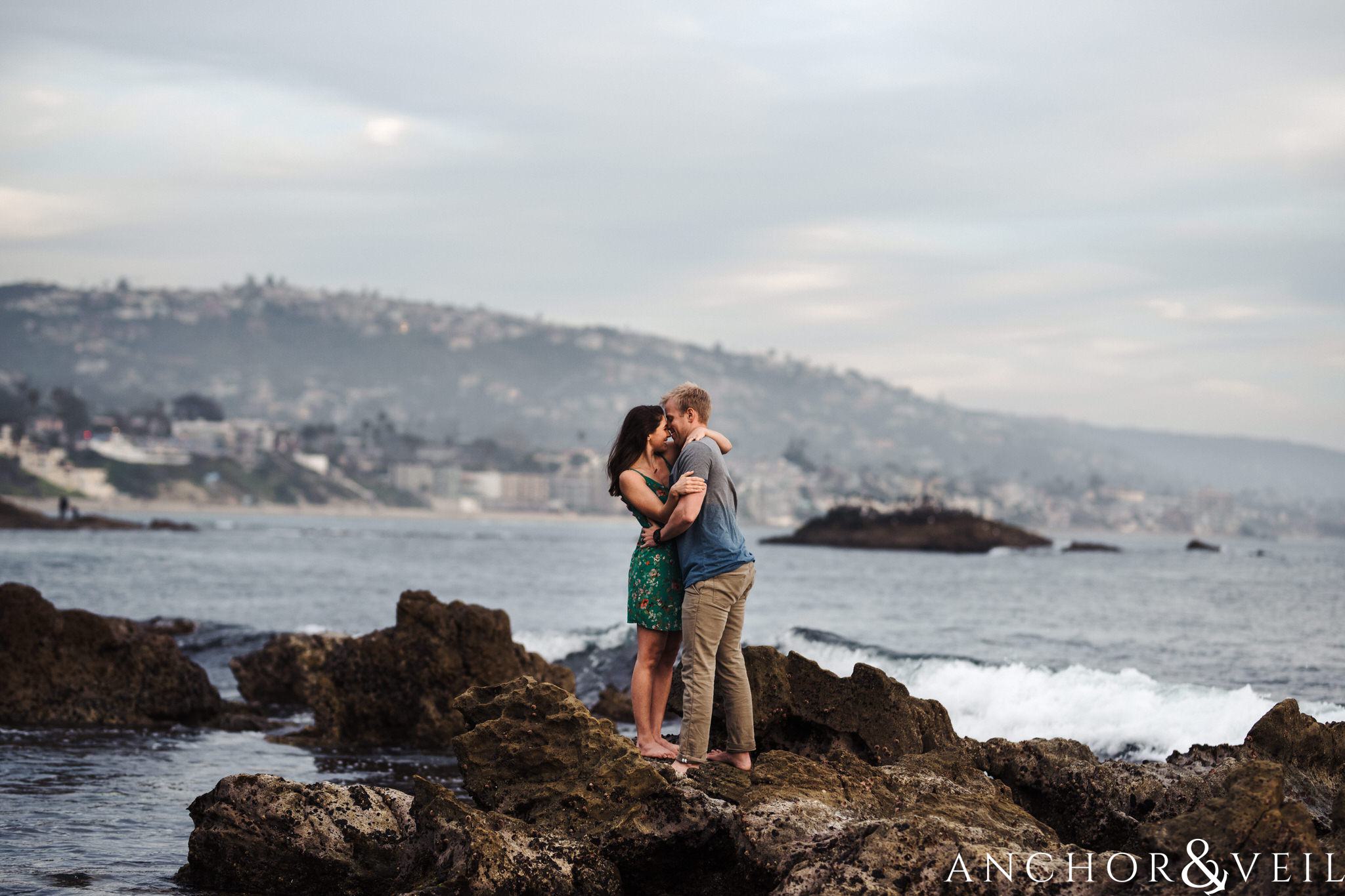 standing on the cliff during their Laguna Beach Engagement Session 