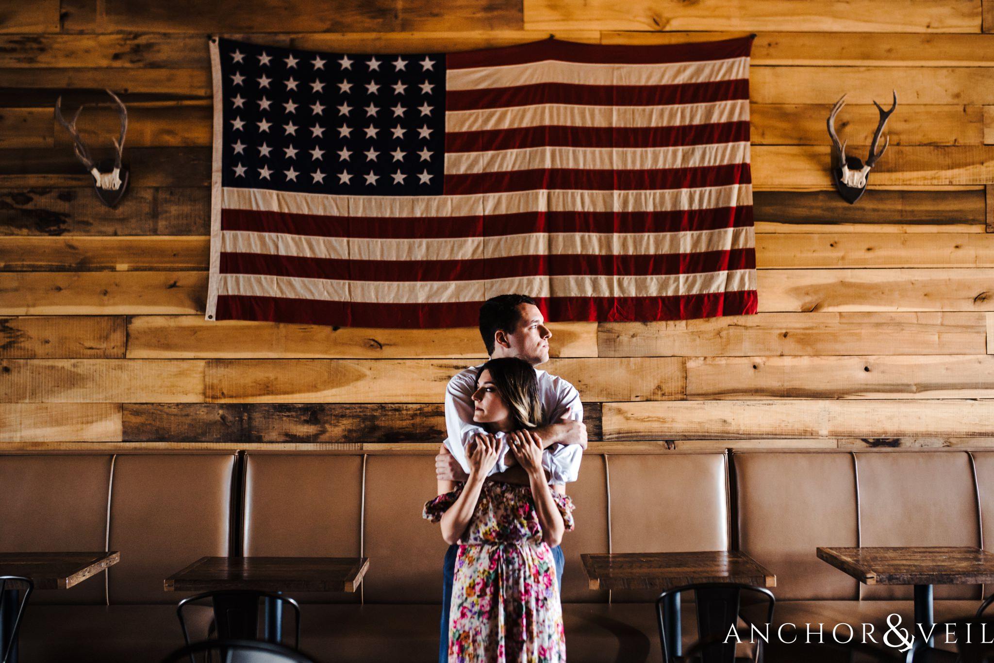 holding under the flag during the Uptown Charlotte Sycamore Brewery Engagement Session