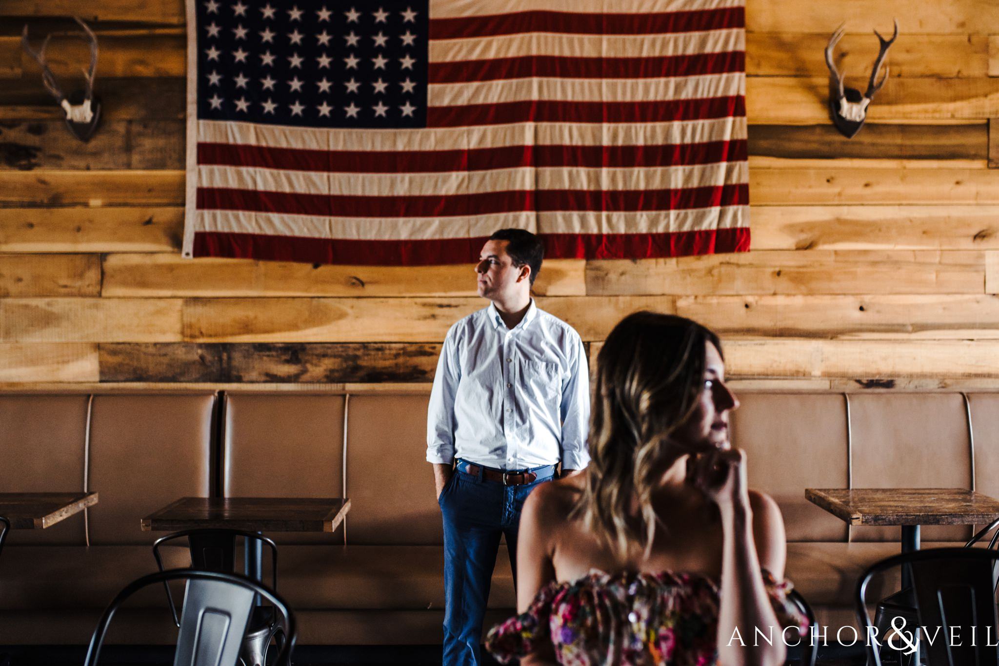 looking off with the flag during the Uptown Charlotte Sycamore Brewery Engagement Session