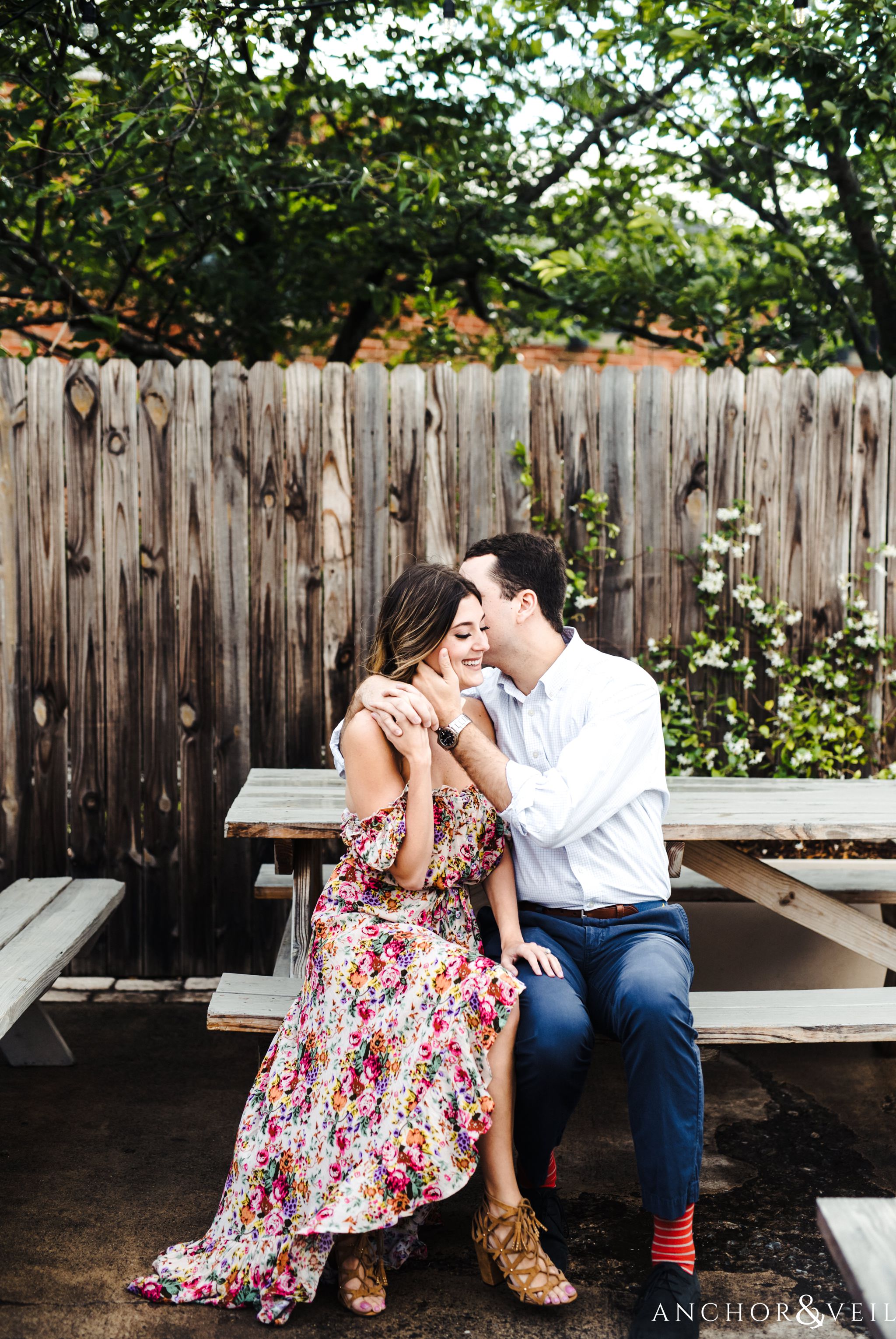 kissing on the beach during the Uptown Charlotte Sycamore Brewery Engagement Session