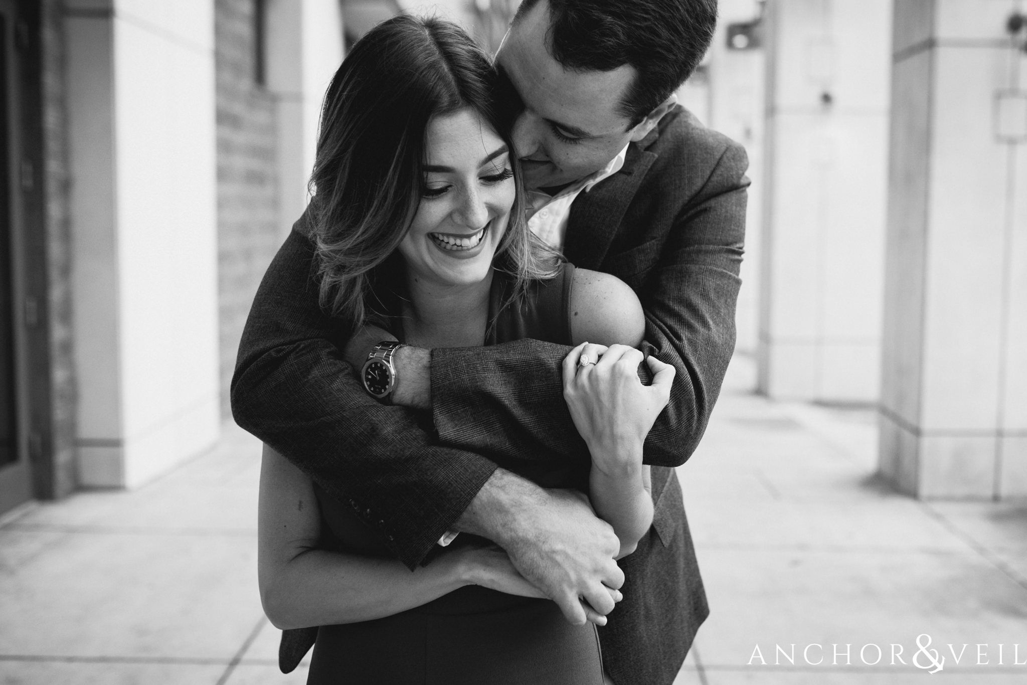 holding her tight during the Uptown Charlotte Sycamore Brewery Engagement Session