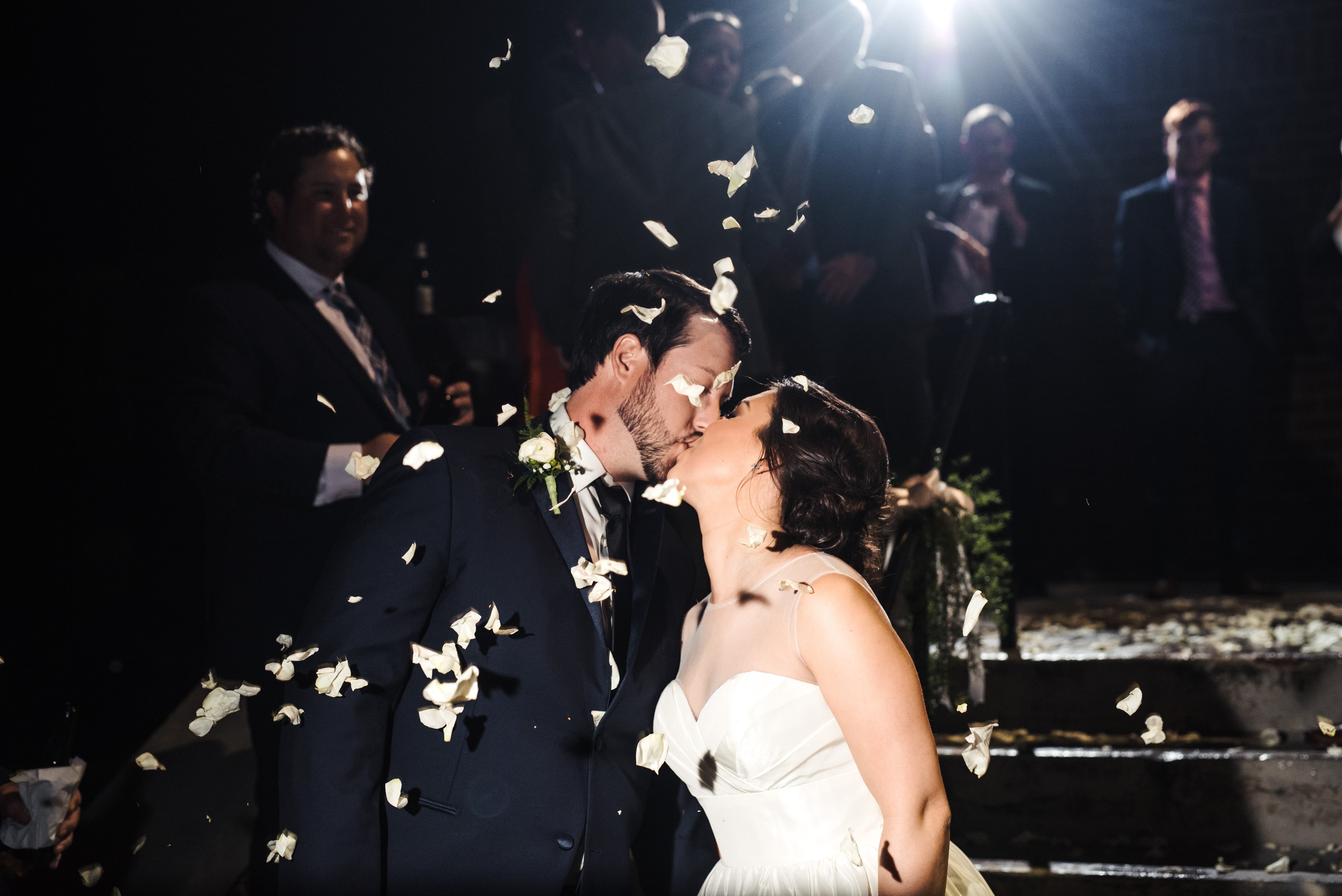 kissing during flower petal exit at mcbryde hall wedding