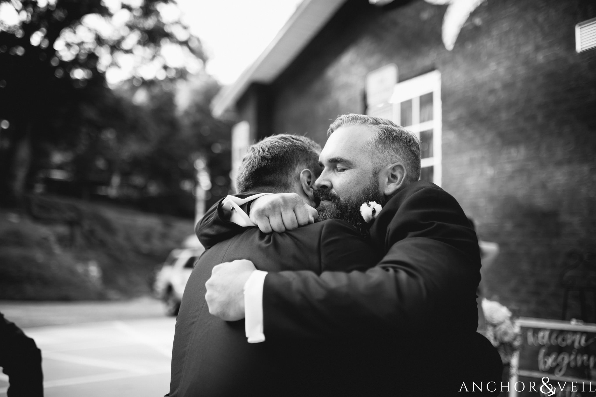 brother hugging groom after wedding 