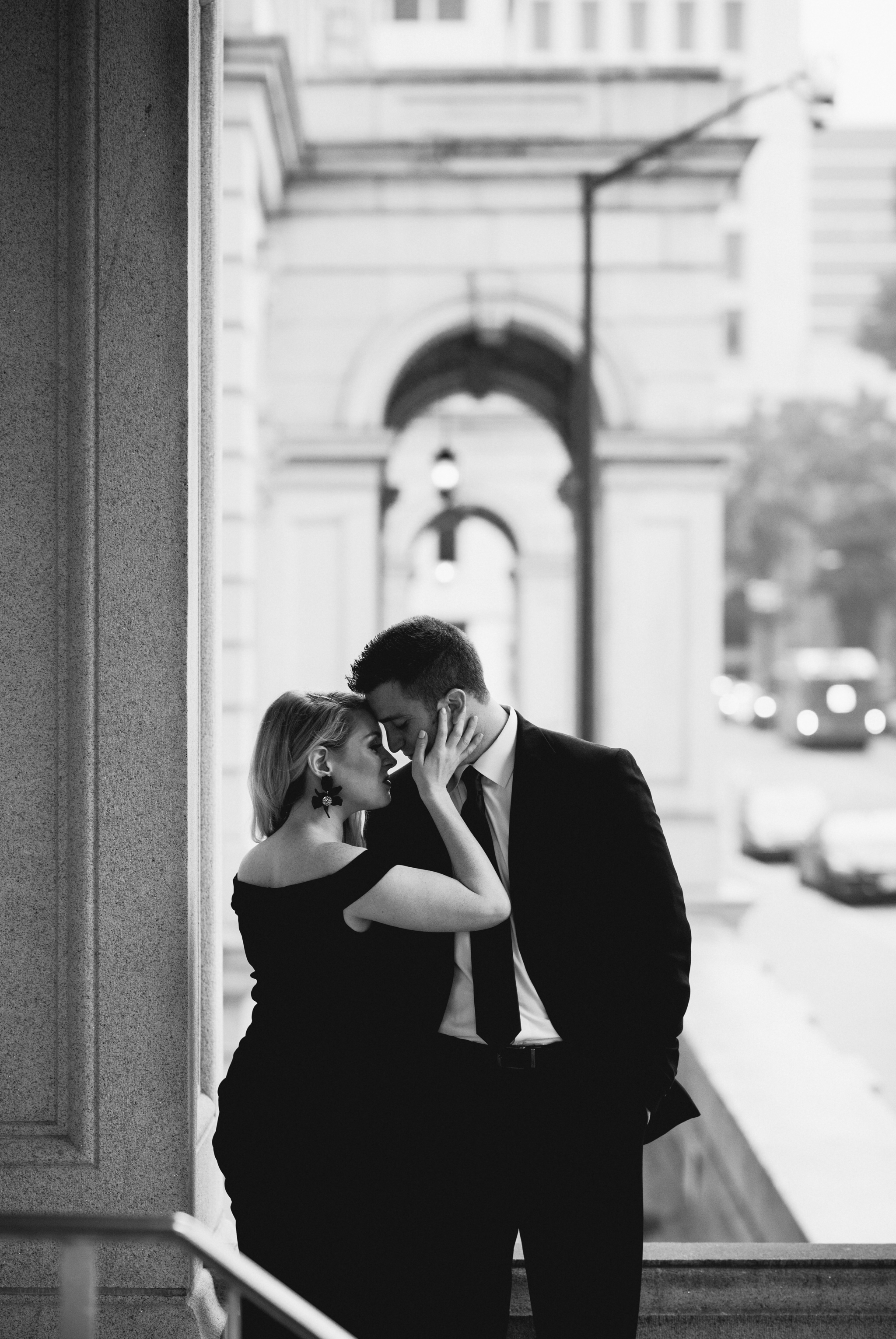 A black and white portrait of a couple share an intimate kiss during their Downtown Richmond Engagement Session