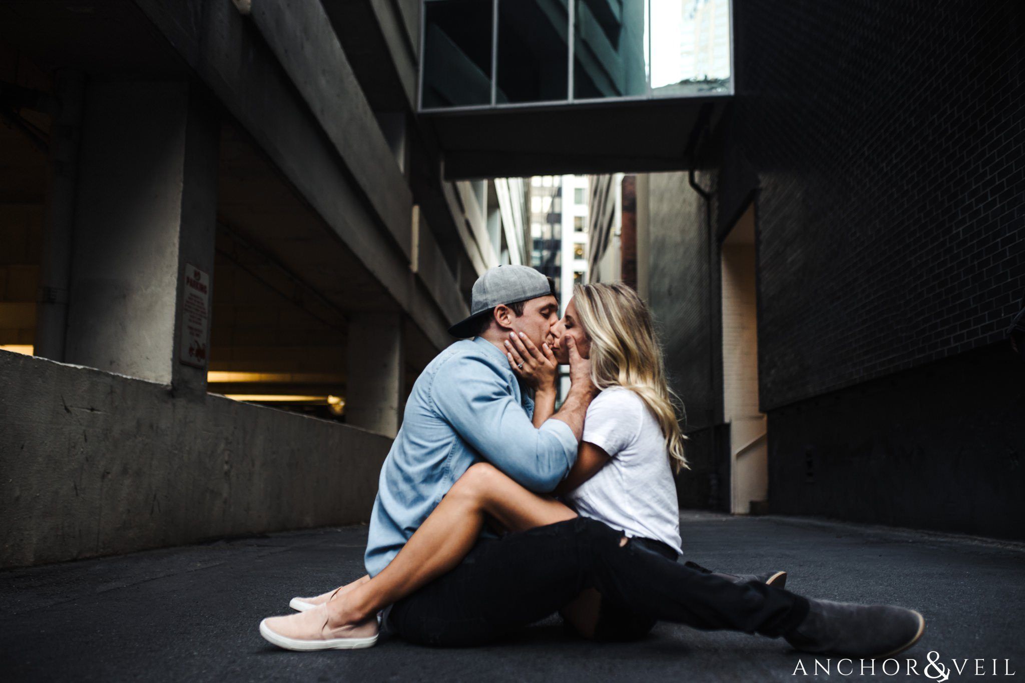 having fun and kissing together in the ally uptown Charlotte engagement session