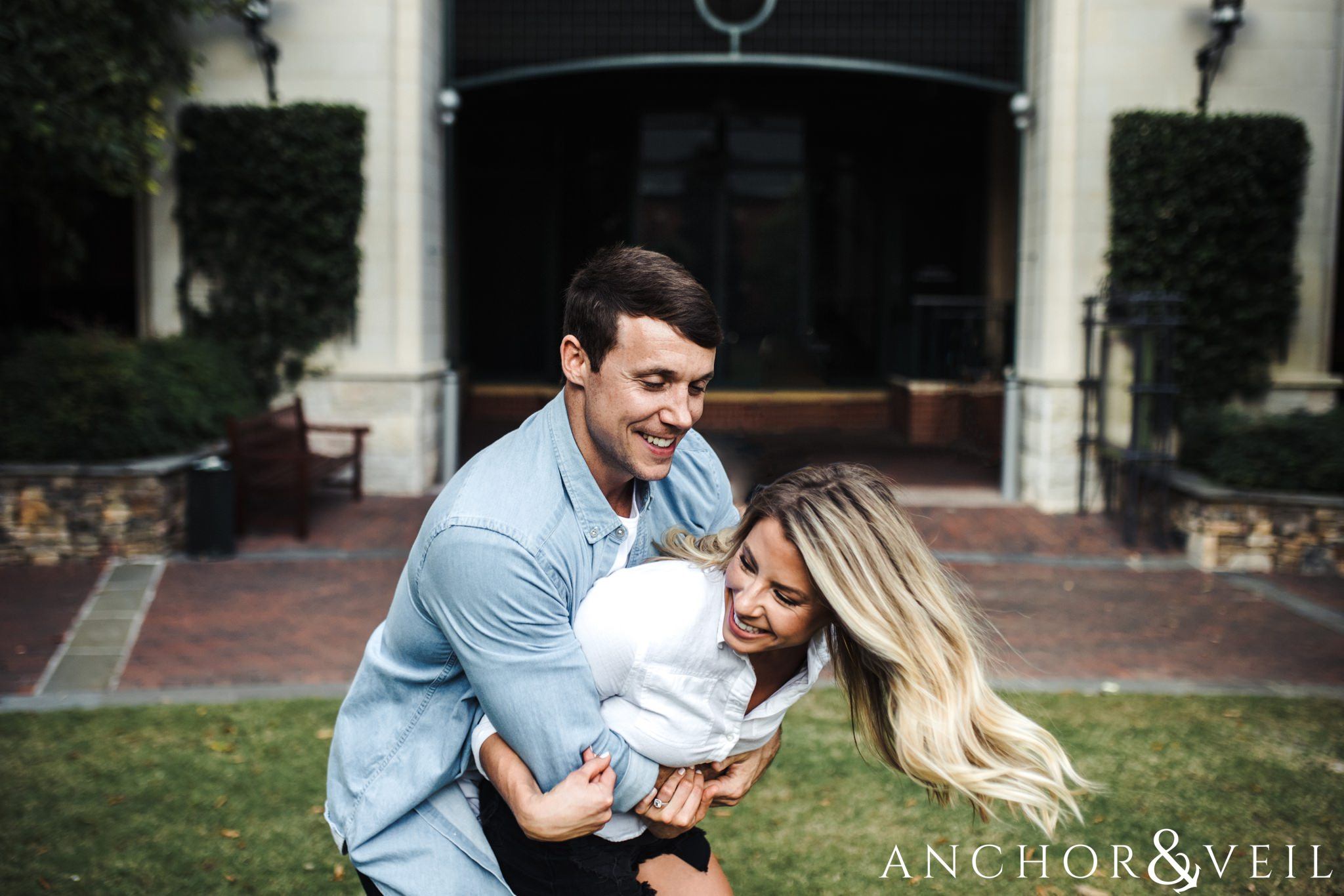 holding her tight and playing uptown Charlotte engagement session