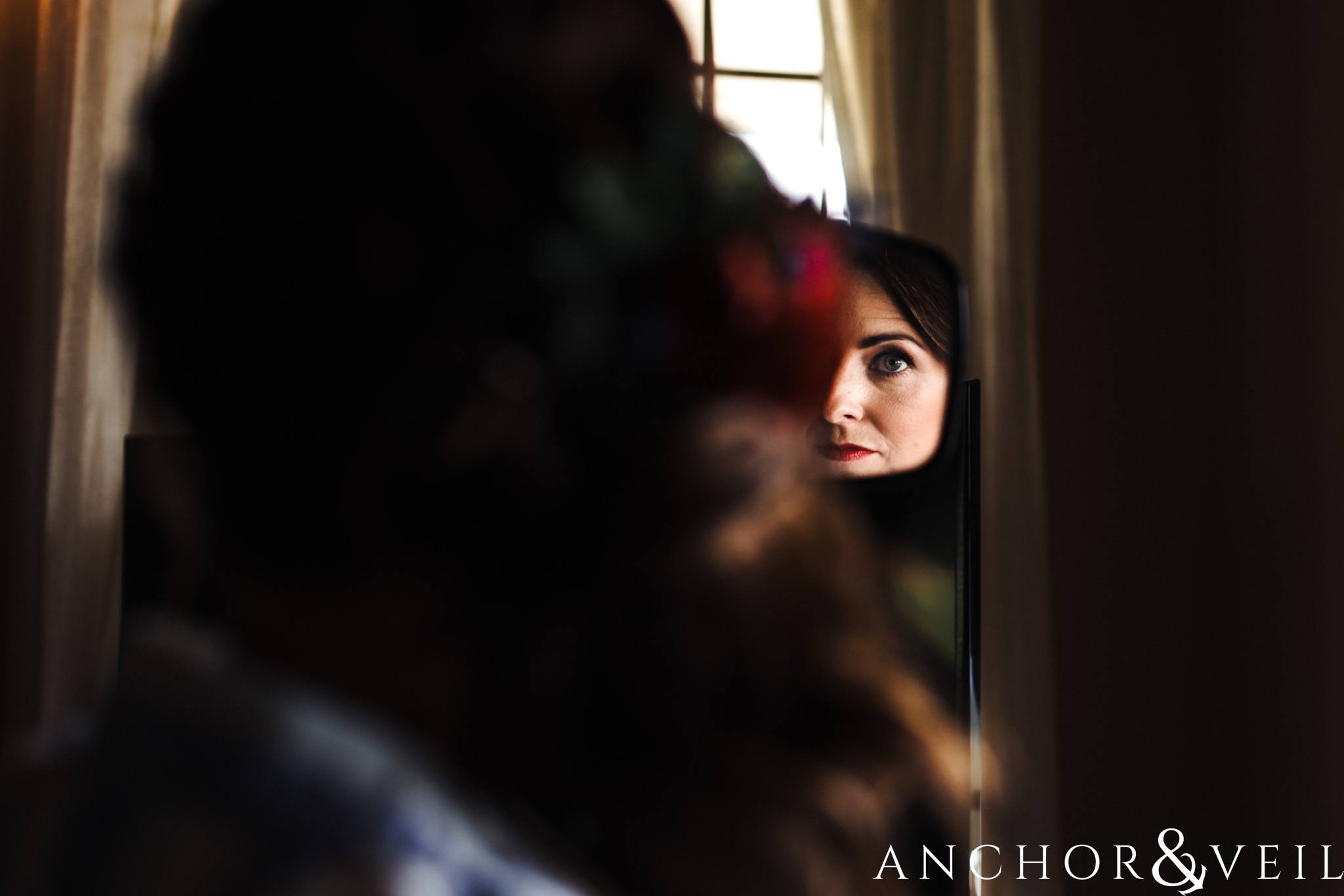 Looking in the mirror during her The Venue Wedding in Asheville