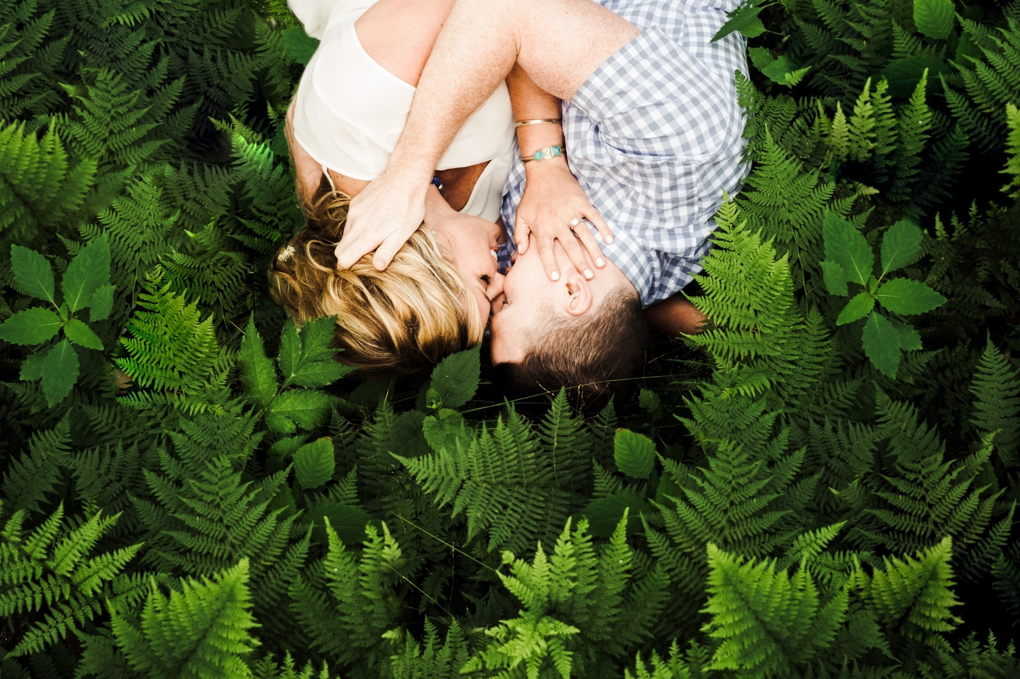 Sweet and passionate couple embracing and about to kiss while laying in the fern during their Craggy Gardens Engagement Session