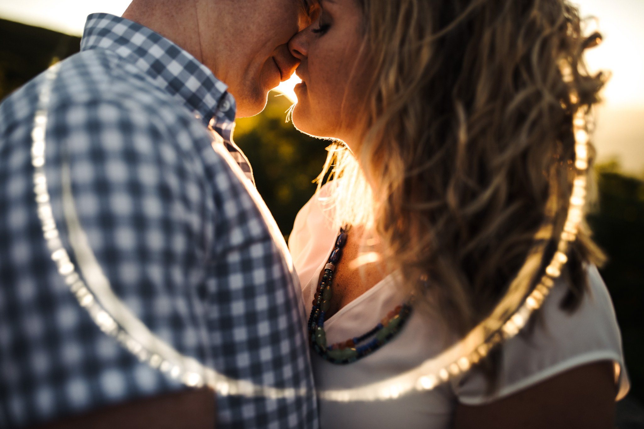 A couple's passionate embrace leaning in for a kiss at sunset during their Craggy Gardens Engagement Session