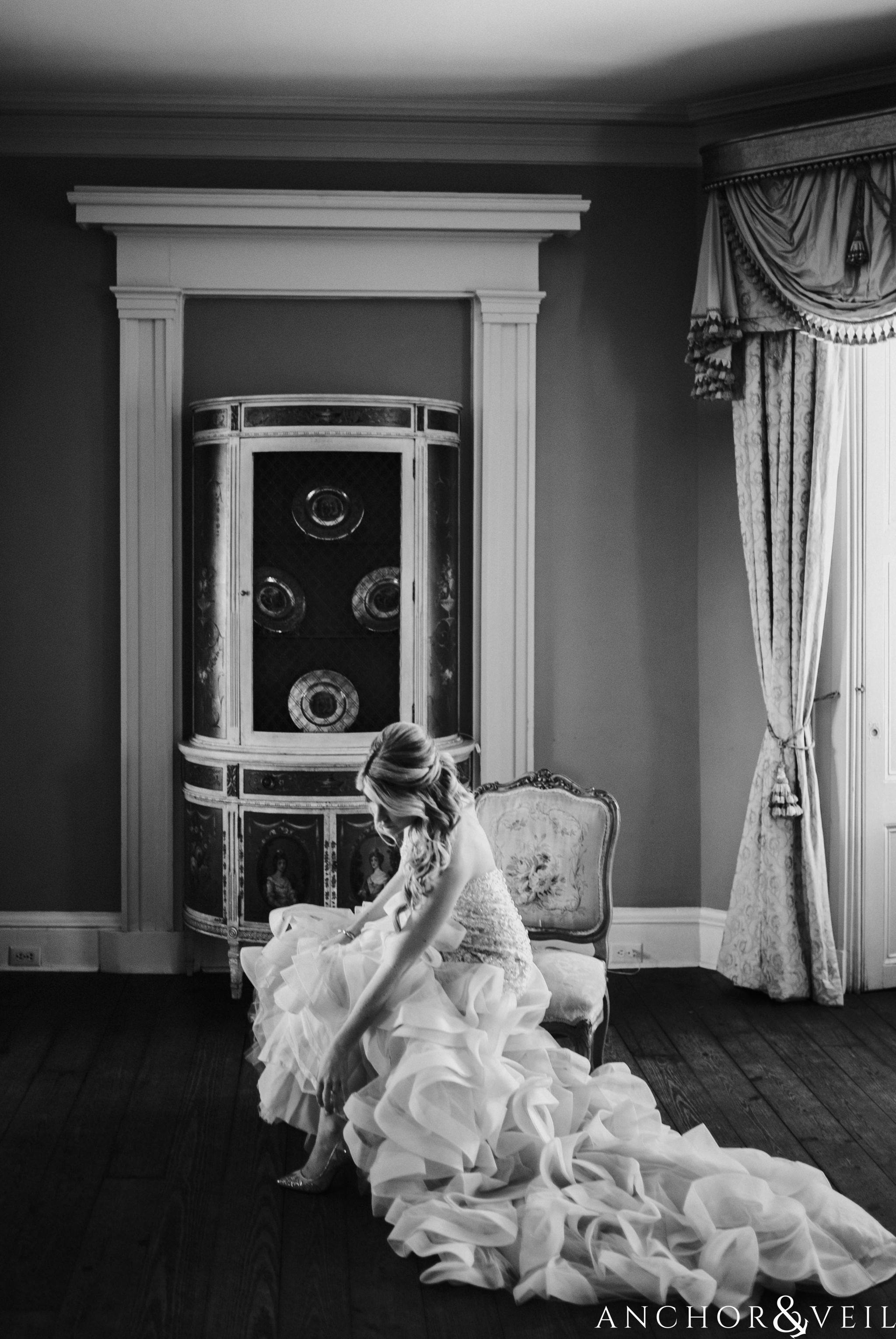 bride putting on her shoes during their William Aiken house Wedding in Charleston Sc