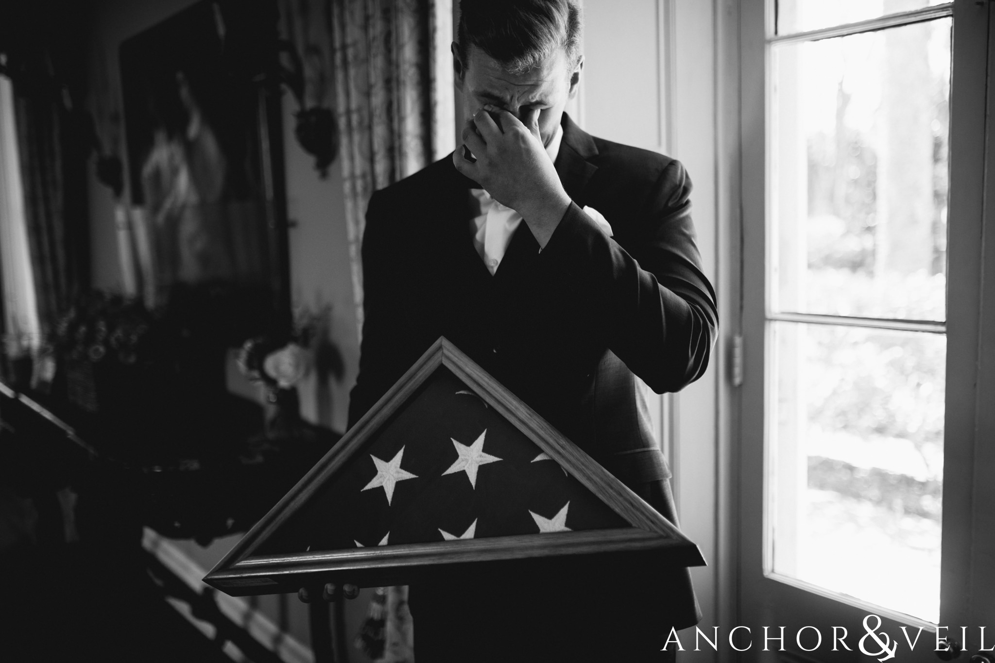 groom crying over flag during their William Aiken house Wedding in Charleston Sc