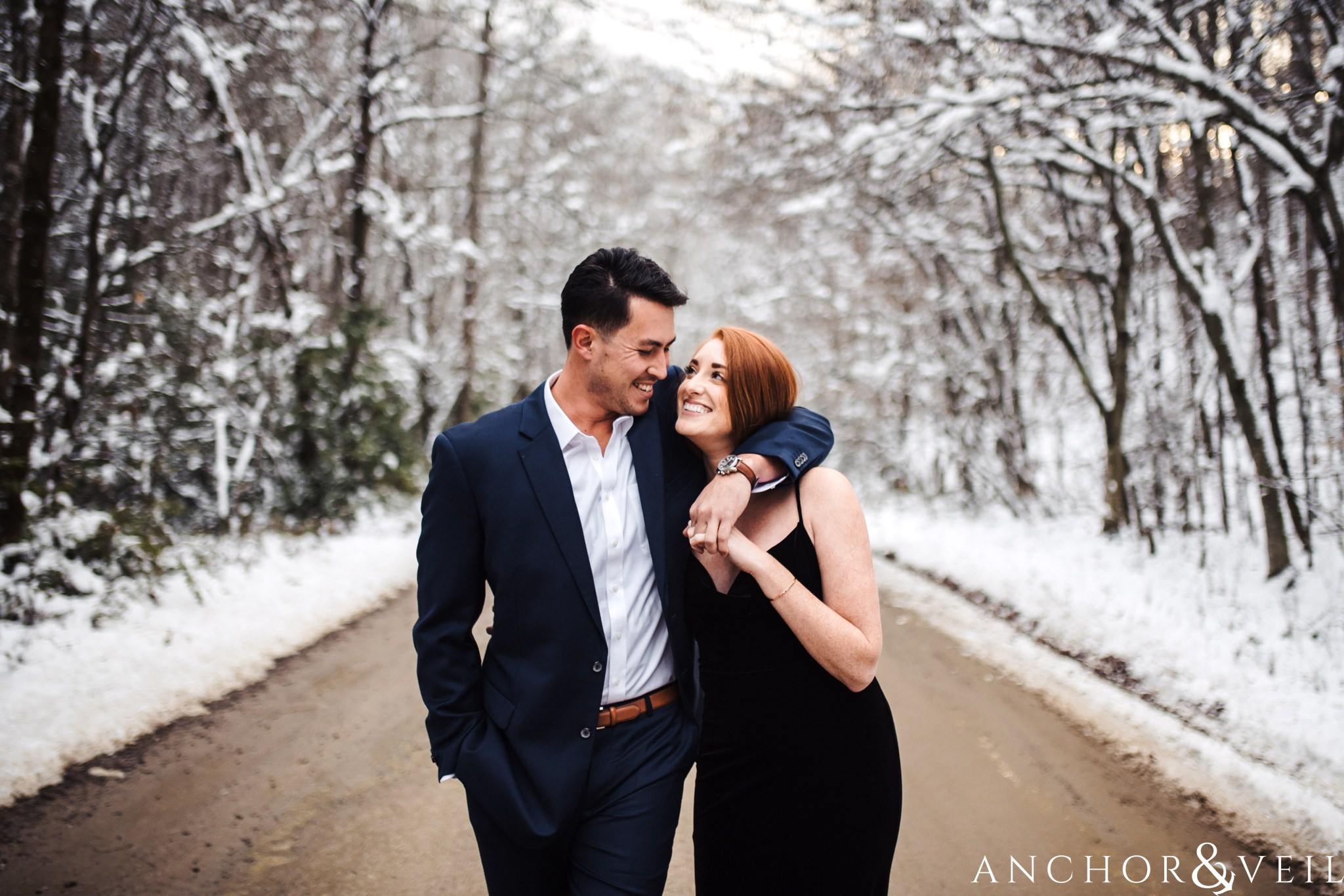 walking down the road holding each other during their Snowy Asheville Engagement Session