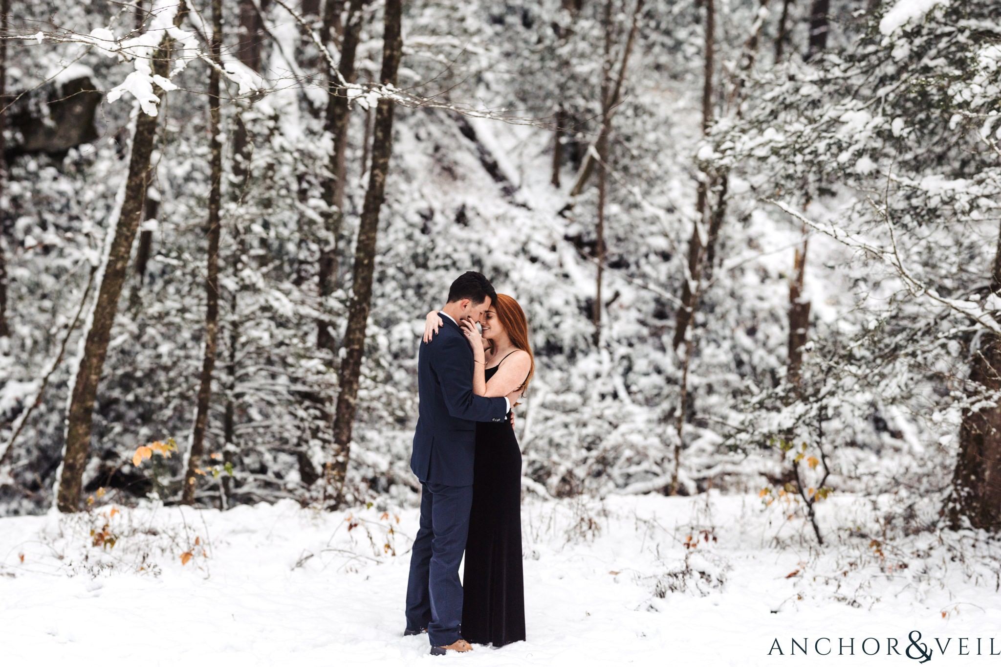 in the trees during their Snowy Asheville Engagement Session