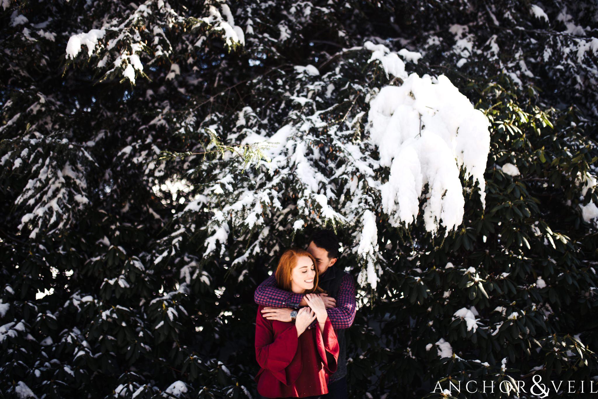 under the snow during their Snowy Asheville Engagement Session