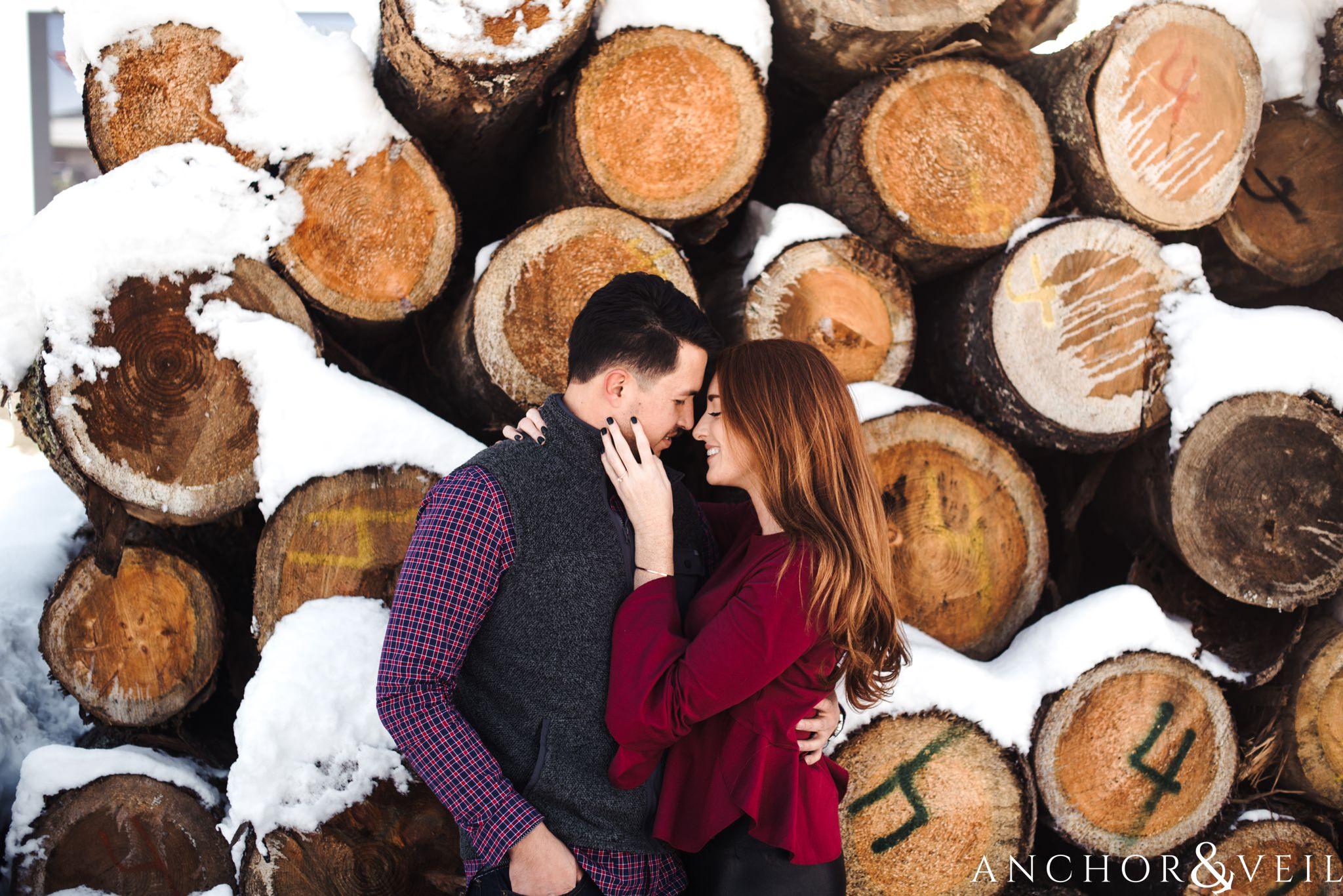 in front of the logs during their Snowy Asheville Engagement Session