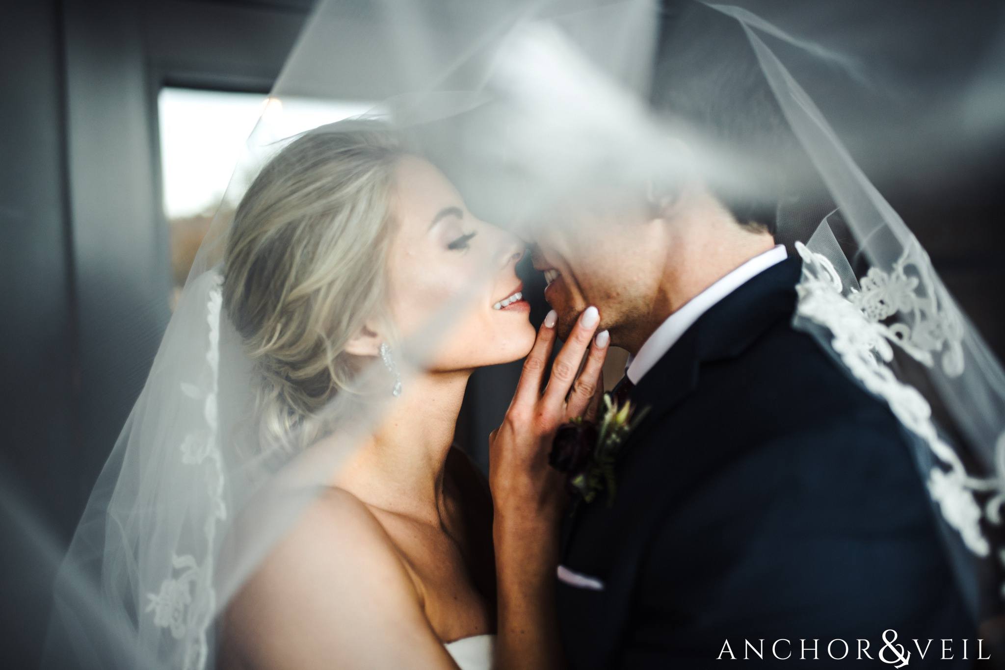kissing under the veil during their Downtown Asheville Wedding