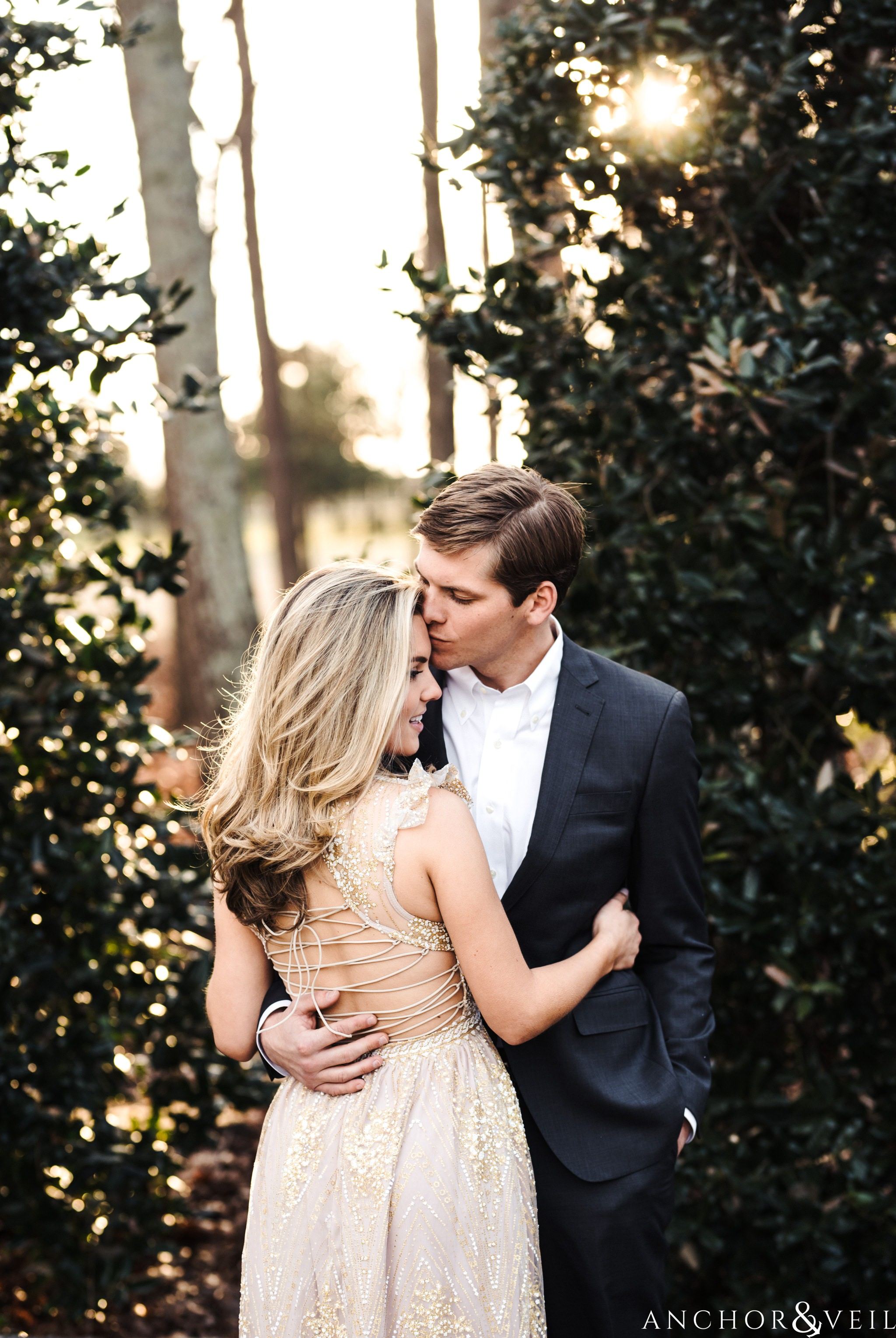 holding her tight and kissing her on the forehead during their Dale Earnhardt Inc Engagement Session Mooresville