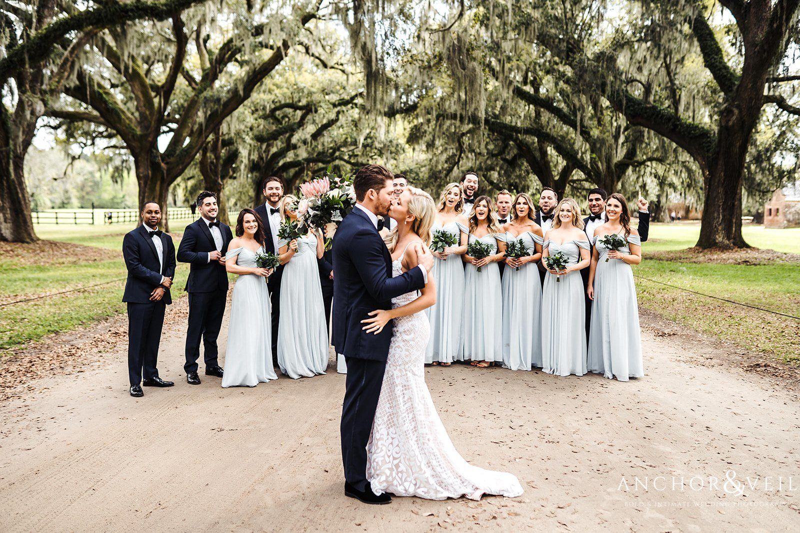 The Bride and Groom kissing in front the wedding party at the Boone Hall Plantation Wedding