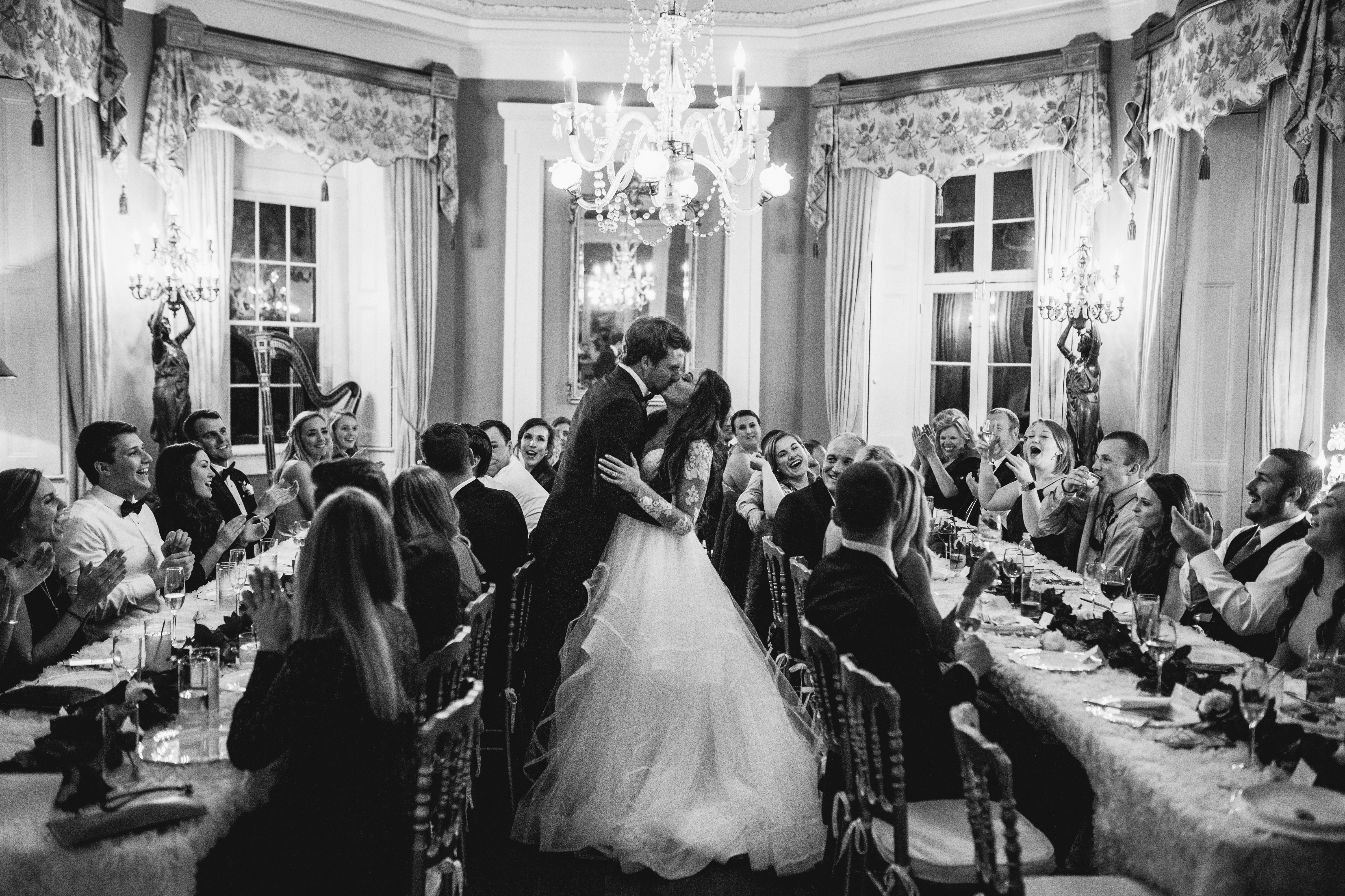 The bride and groom kissing during the dinner at the William Aiken House Wedding