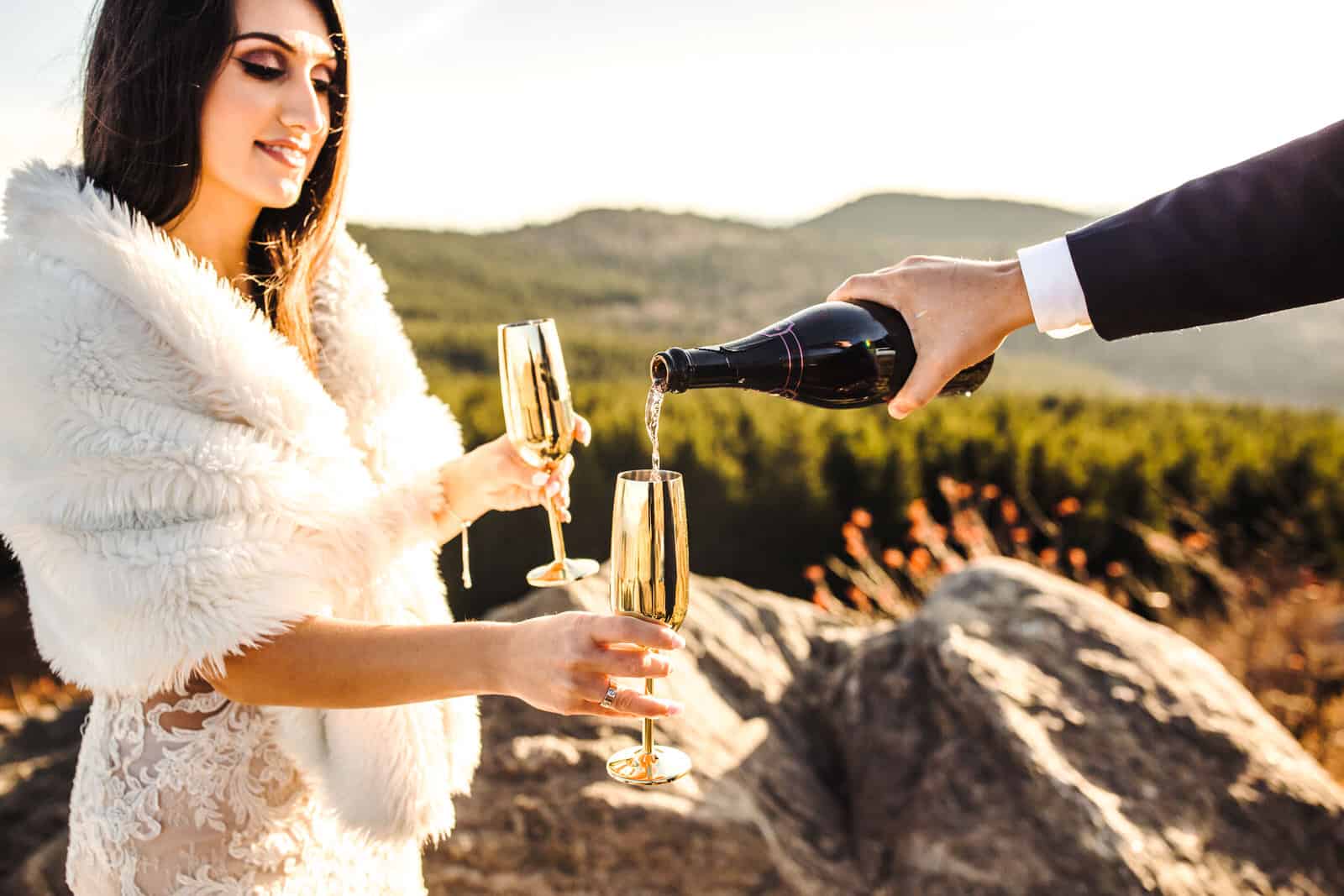 Pouring champagne after their Destination Wedding Elopement