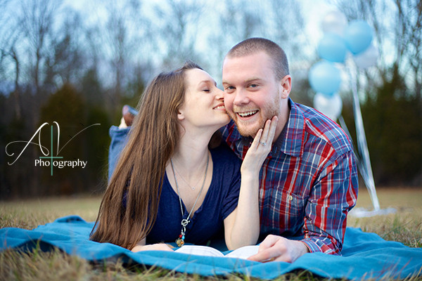 A couple laying on a blanket in an open field during their Downtown Concord Engagement Session