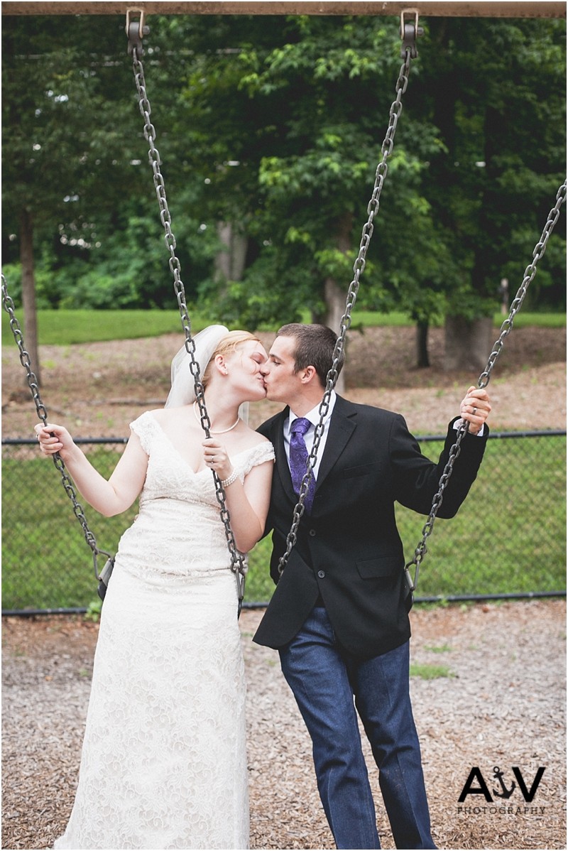 The Bride and Groom kissing on the swing after the wedding ceremony at the summerfield amphitheater in North Carolina