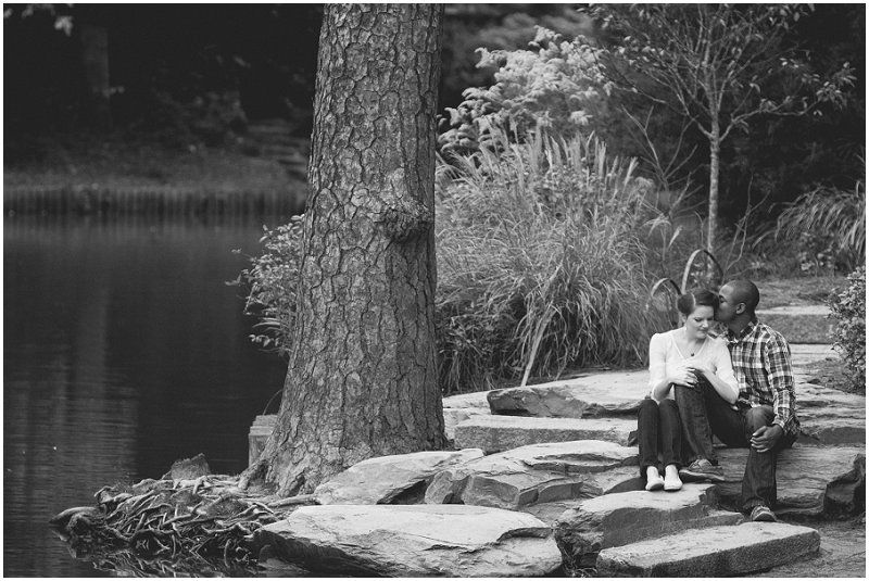 Sitting on the rocks next to the pond at the Duke Gardens during the Duke gardens engagement session
