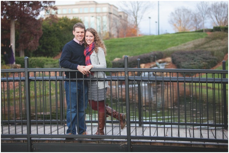 on the bridge with a building background during the fall couples session in charlotte Ballantyne business park North Carolina