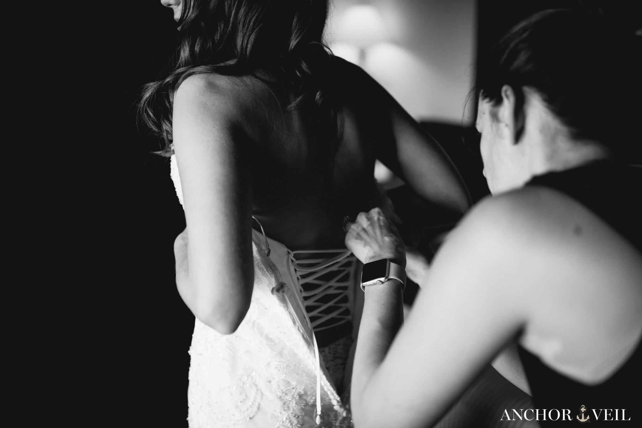 bride getting her dress tied together 