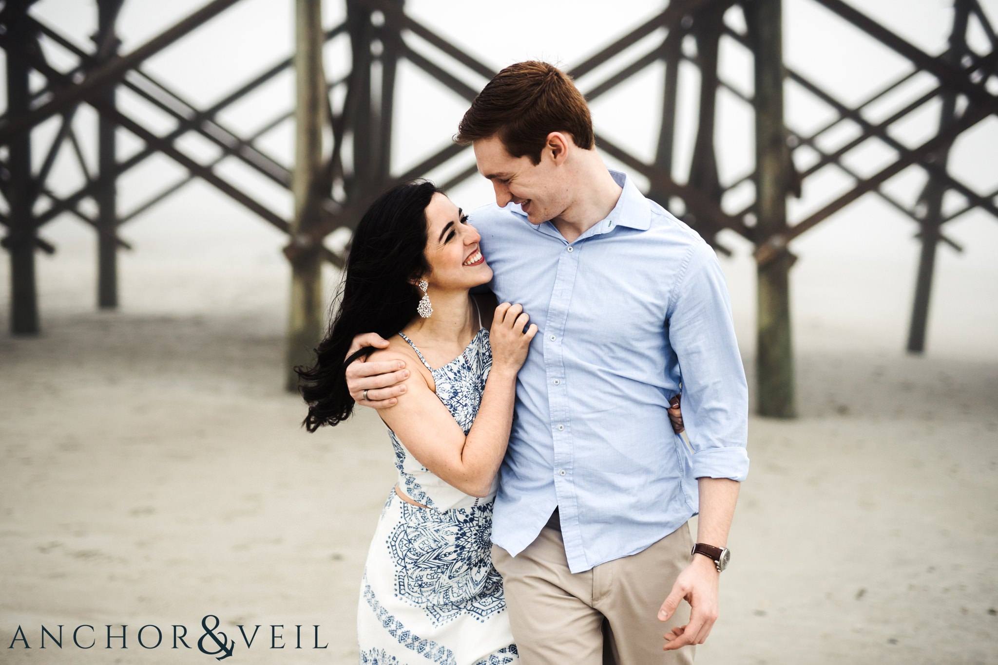walking near the pier during their folly beach and legare waring house engagement session