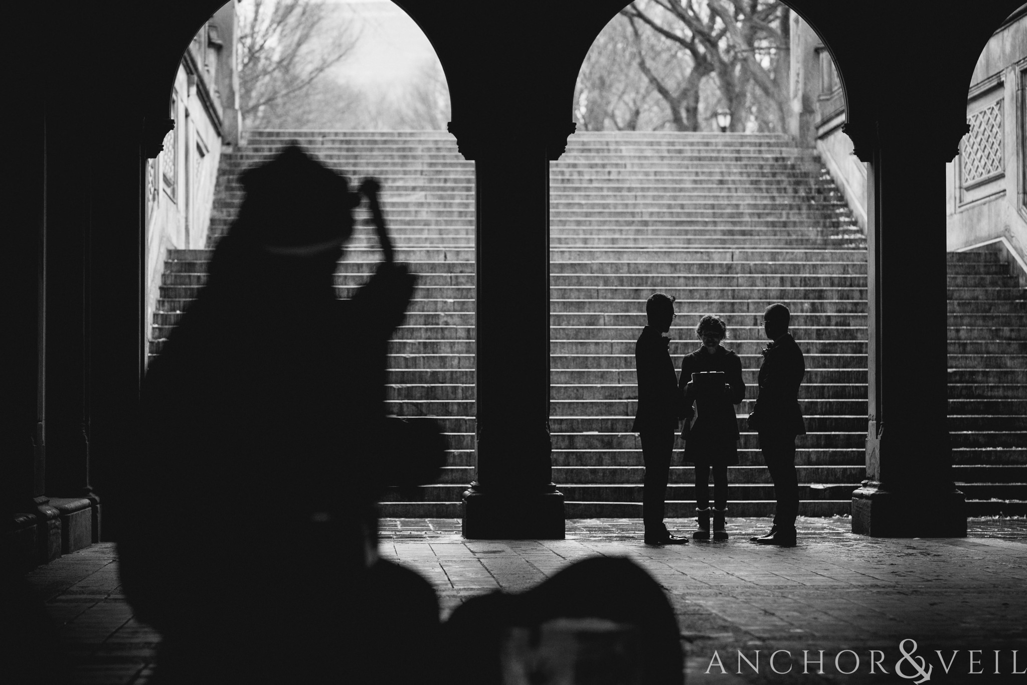 man playing an instrument during the ceremony during their central park elopement in bethesda Terrace