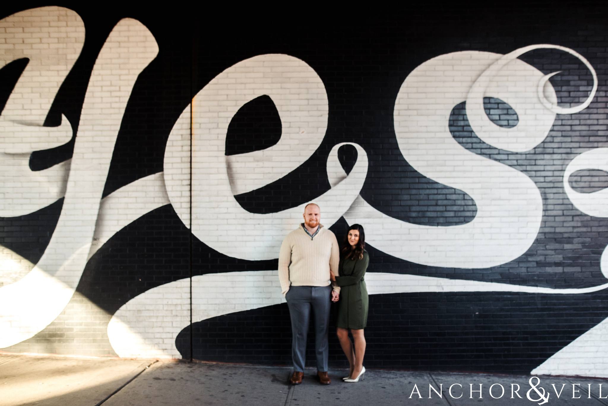 Yes mural in During their Dumbo Brooklyn New York engagement session