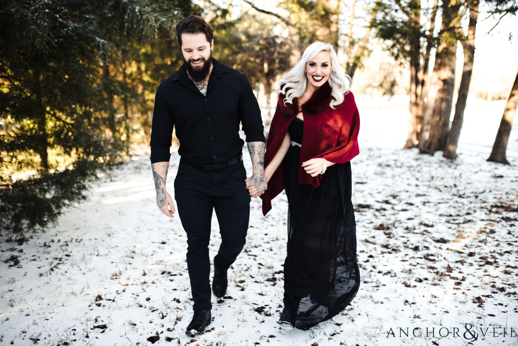 walking hand in hand during their charlotte snow engagement session