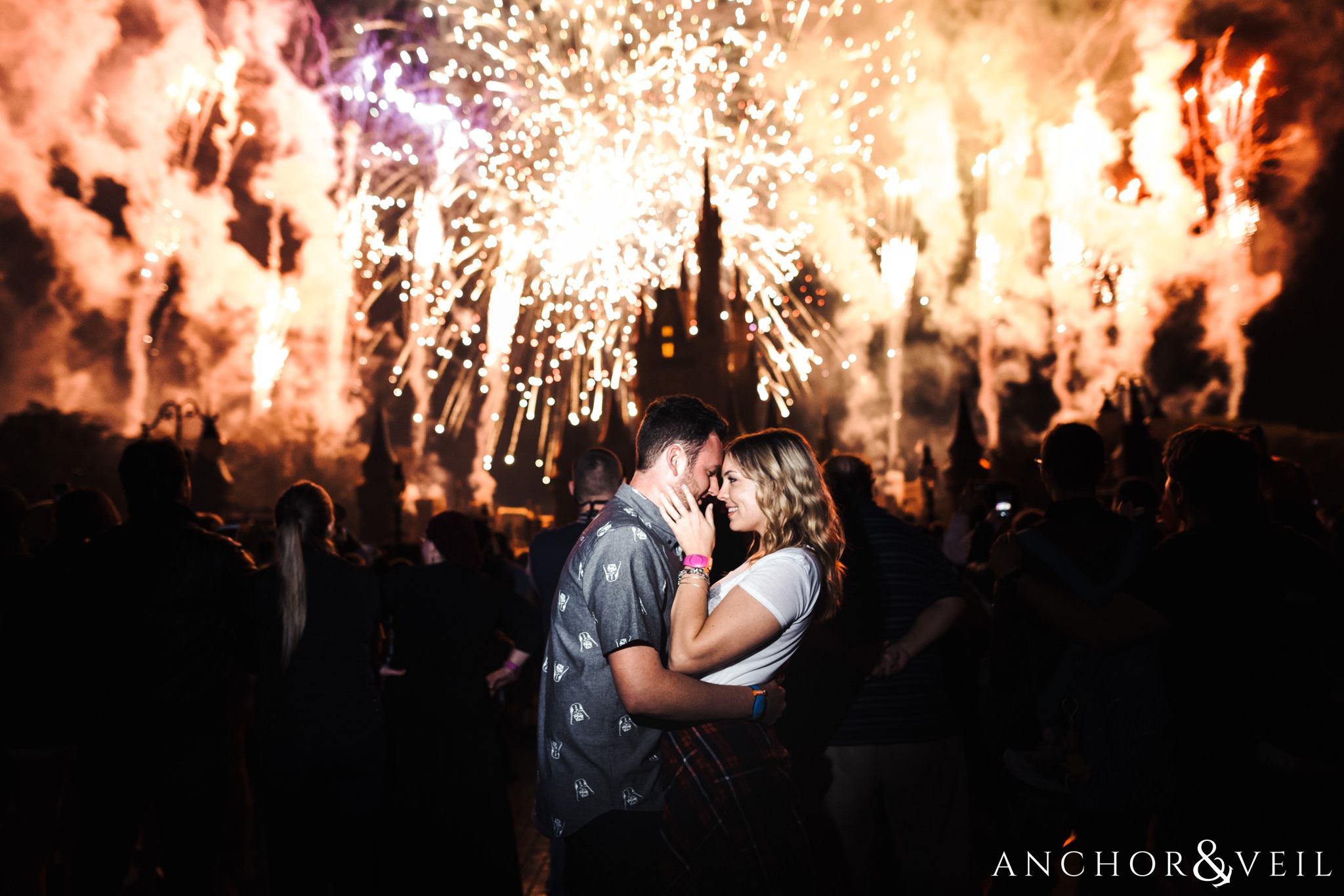 Disney Castle Fireworks love during their Disney world engagement session at Disney's Magic Kingdom
