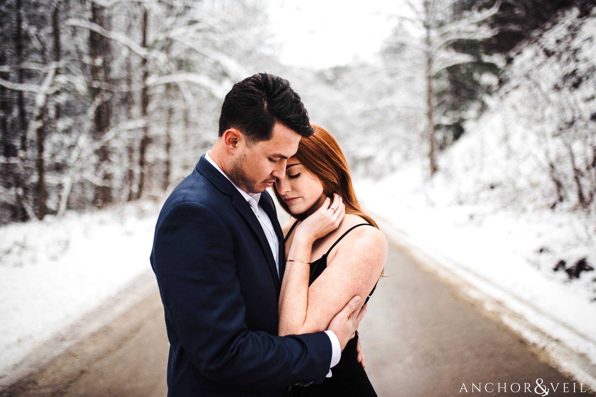 holding her tight on the road during their Snowy Asheville Engagement Session