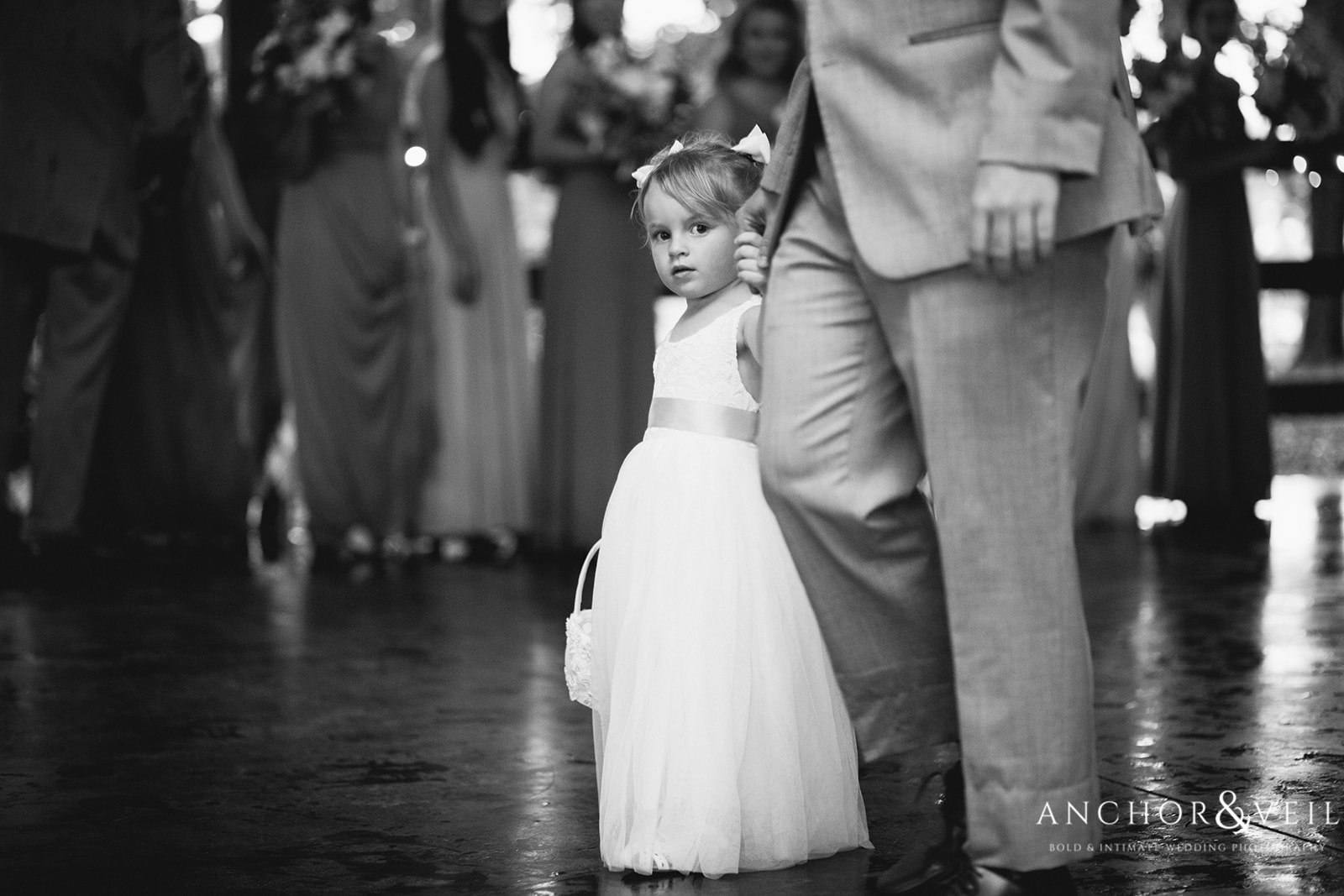 The flower girl being escorted down the isle before the ceremony begins at The Farm at Brusharbor Wedding