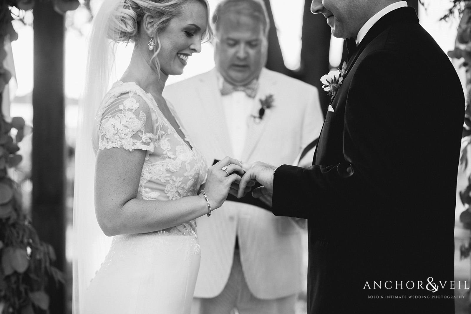 The bride placing the ring on the groom's hand during the ceremony at the Lowndes Grove Plantation Wedding