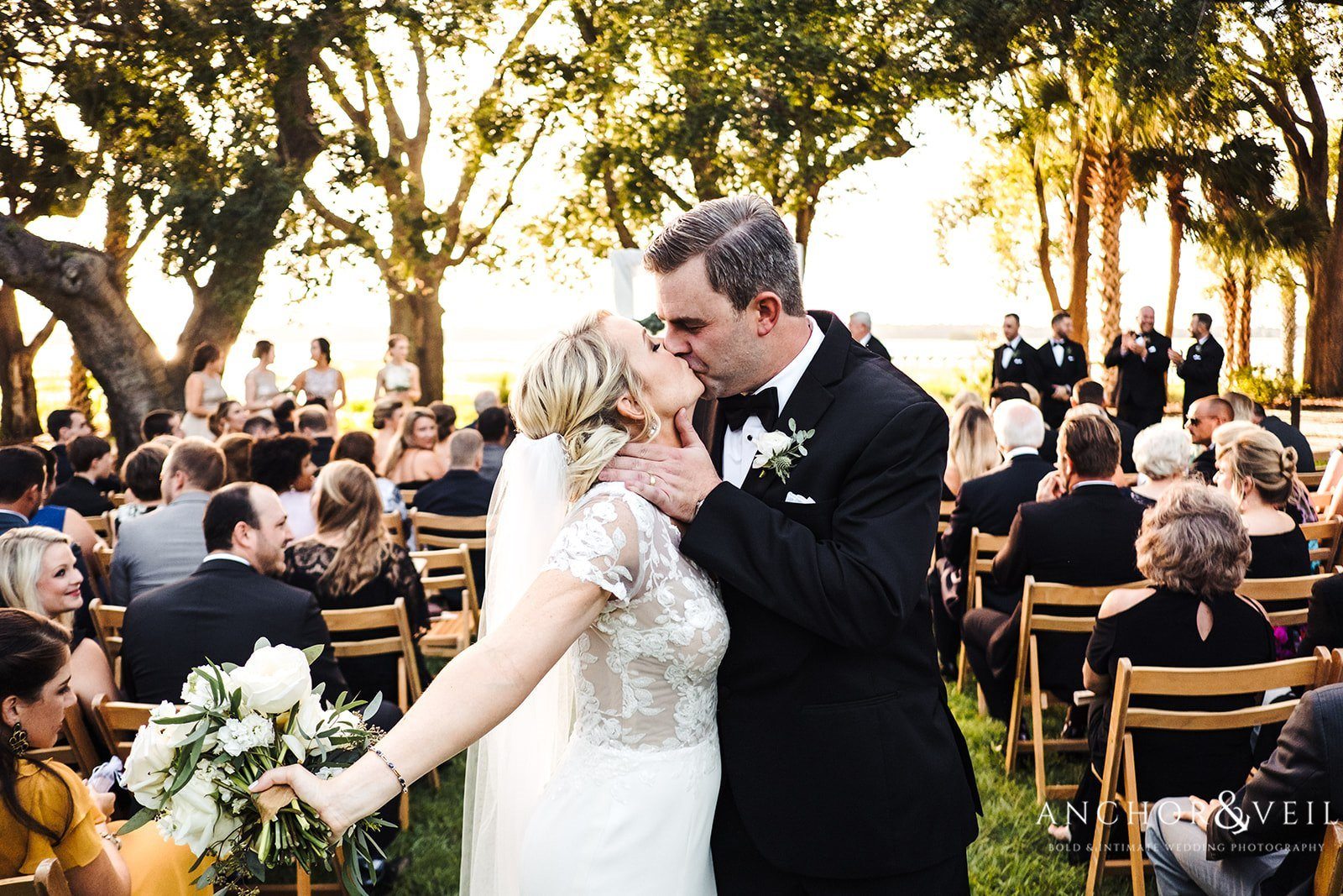 The bride and grooms kiss after walking down the isle at the Lowndes Grove Plantation Wedding