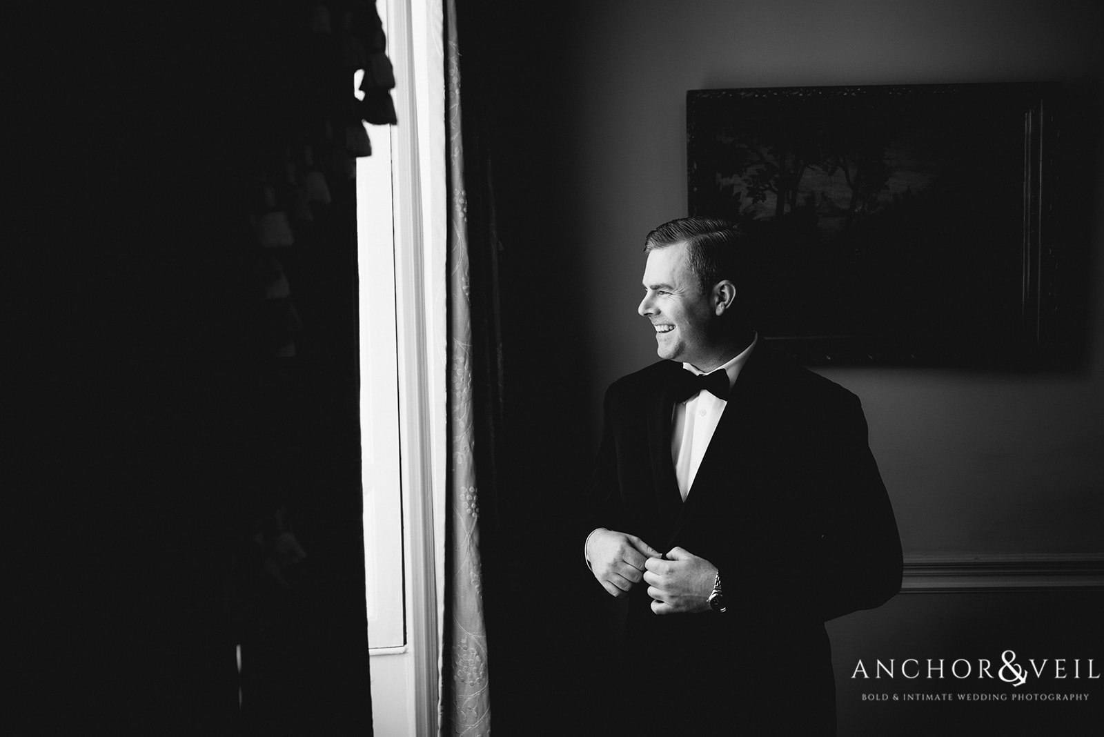 The groom standing at the window at the Lowndes Grove Plantation Wedding