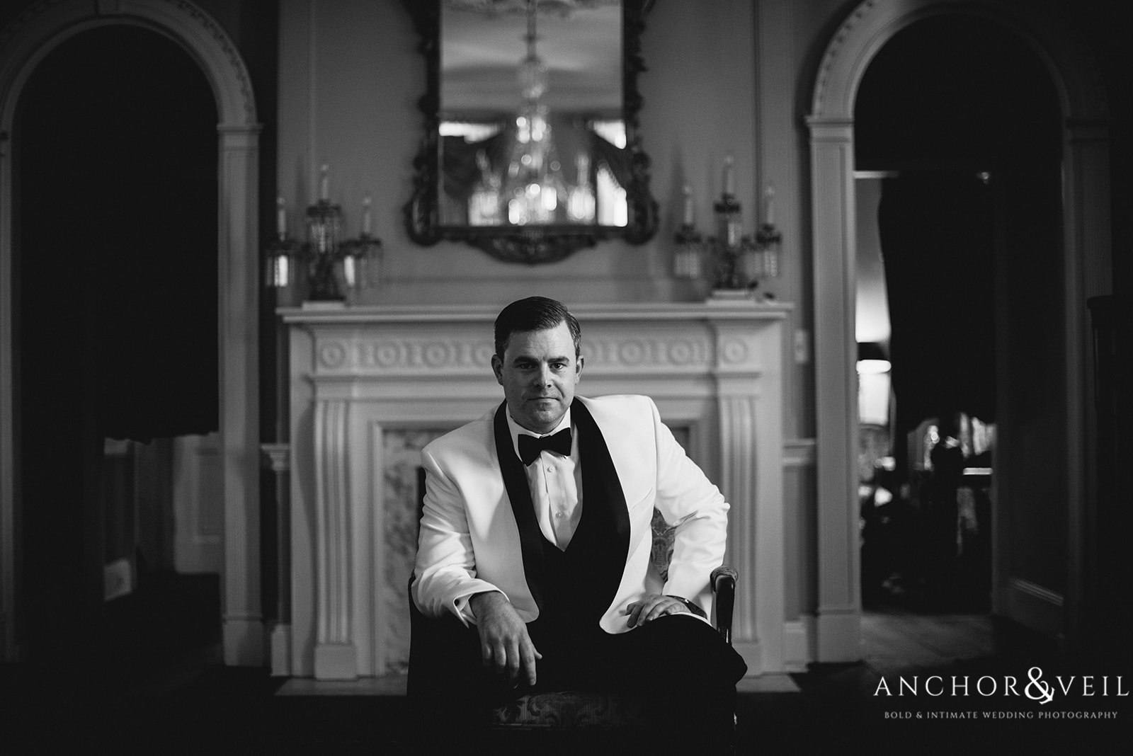 The groom sitting in dinner jacket at the Lowndes Grove Plantation Wedding