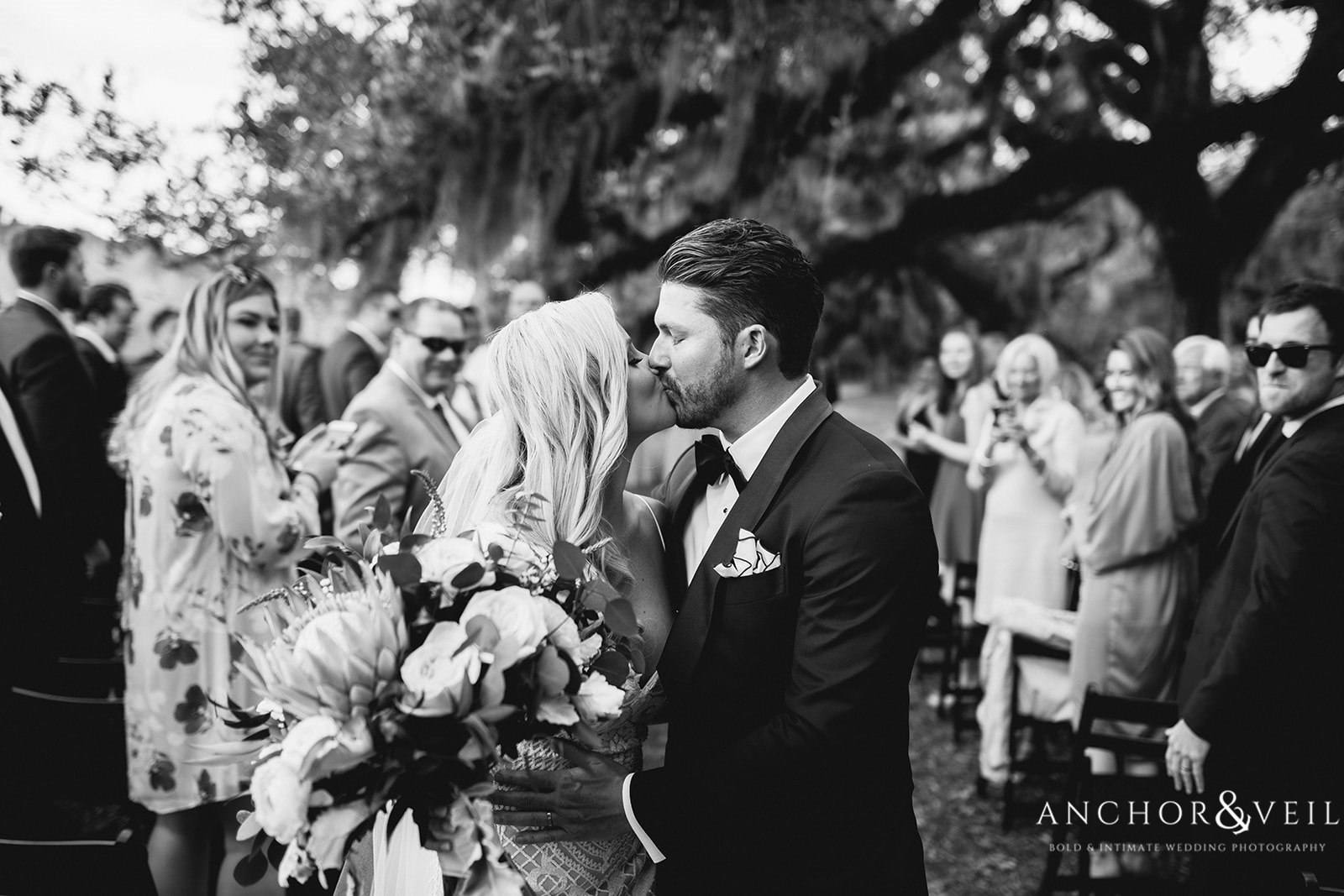 The bride and groom kiss after walking down the aisle as "man and wife" at the Boone Hall Plantation Wedding 