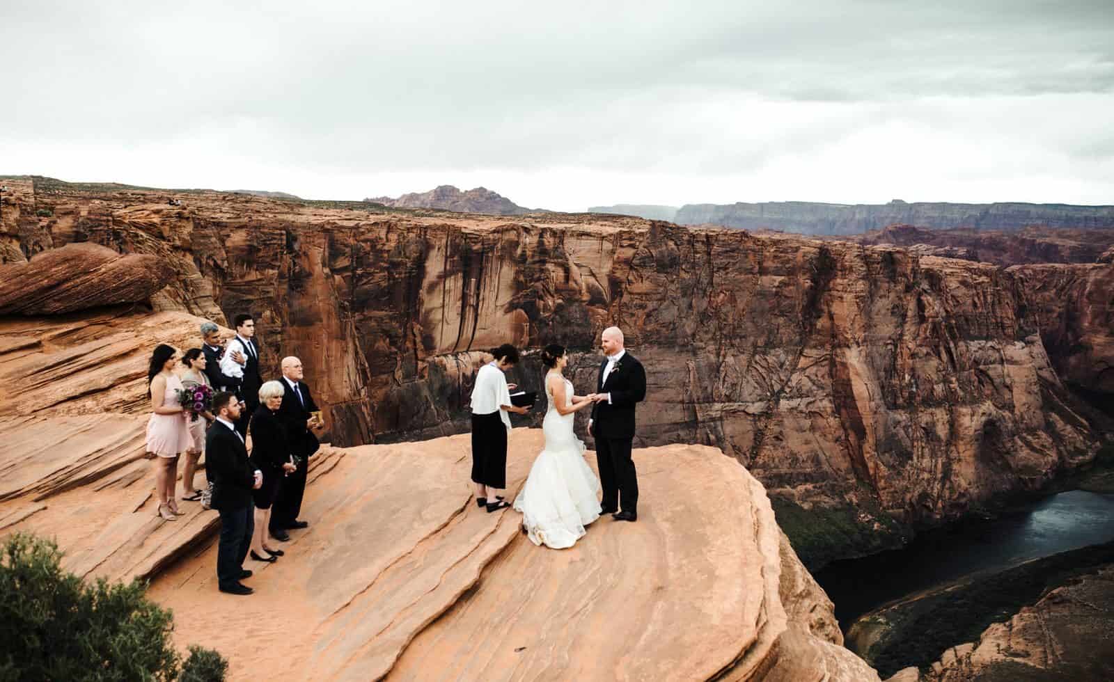 Standing together with family during their ceremony at Horseshohe bend for their Destination Wedding