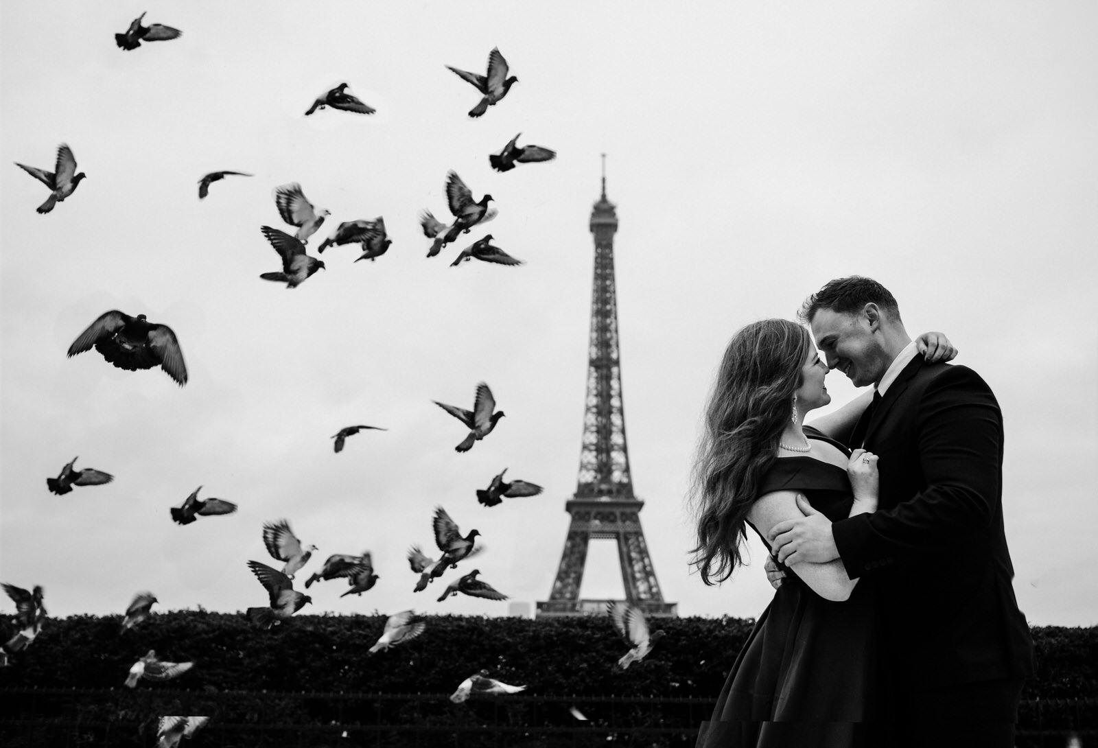 Black and white photograph of a couple with a sweet embrace with the Eiffel Tower in the background of their Paris, France Destination Wedding 
