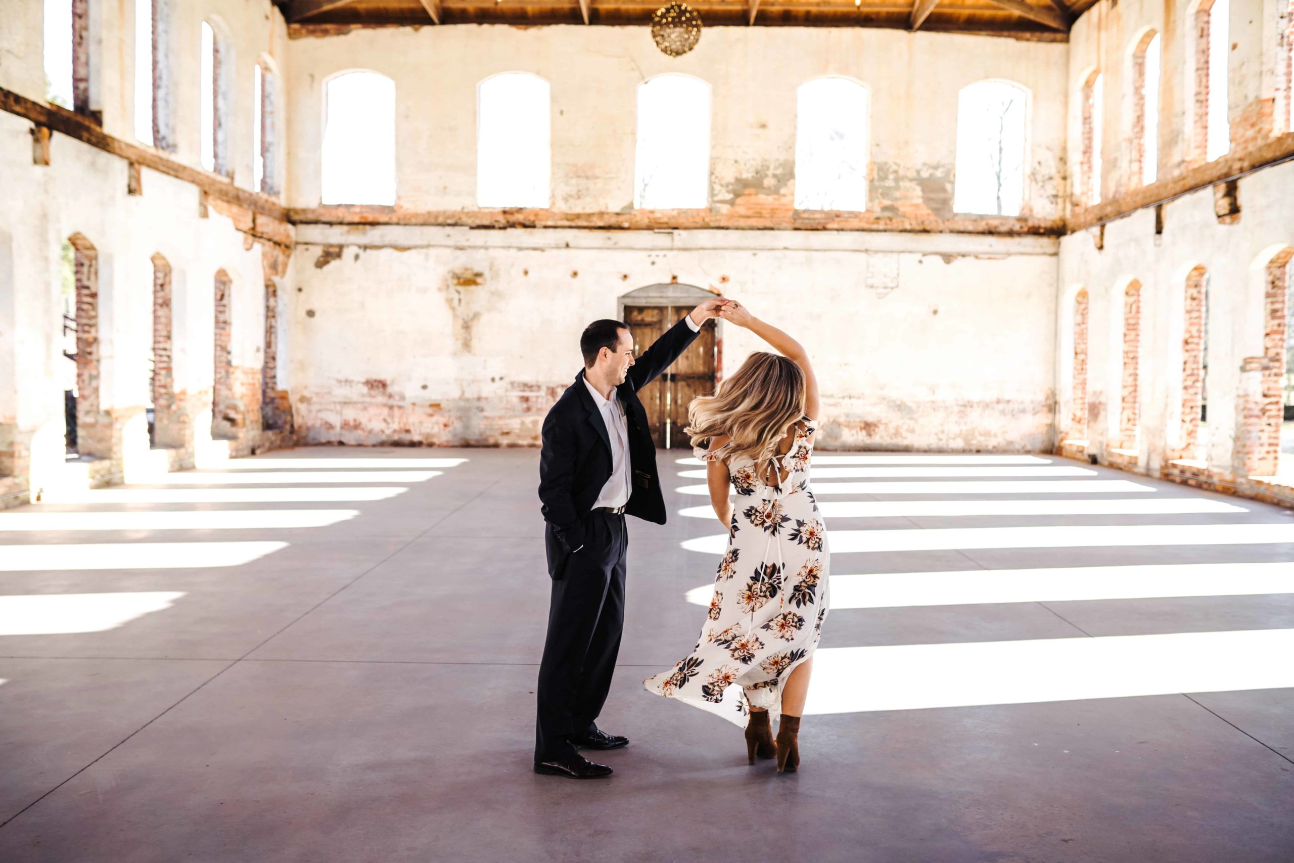 A groom-to-be twirling his bride-to-be in the interior of The A couple with a sweet embrace at Providence Cotton Mill during their Engagement Session